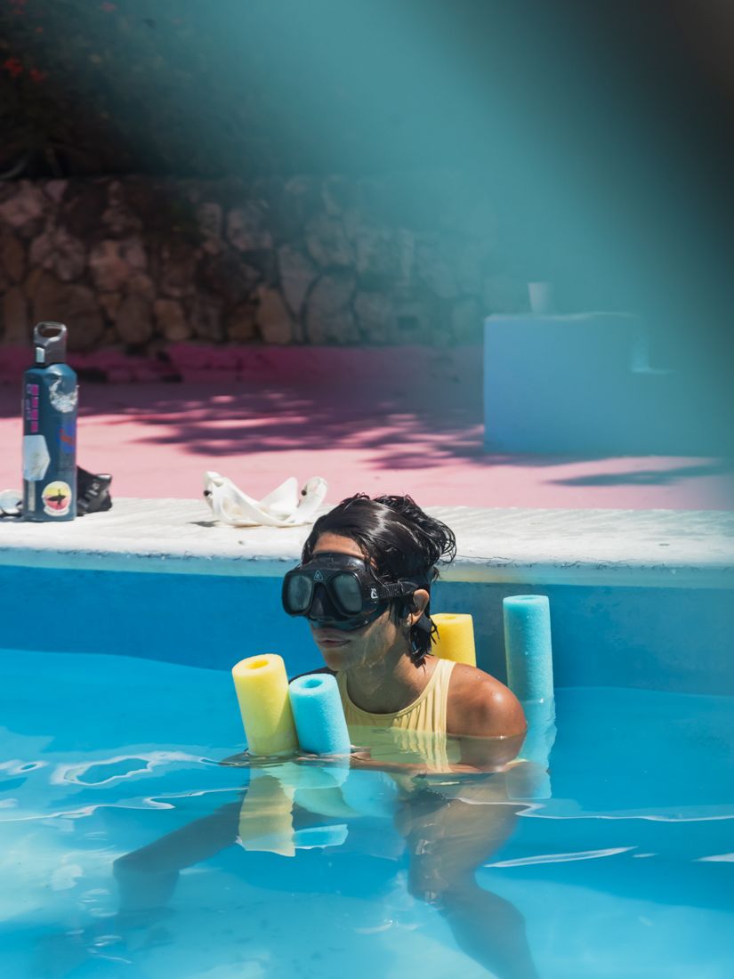 Estudiante con máscara de apnea preparándose en la piscina